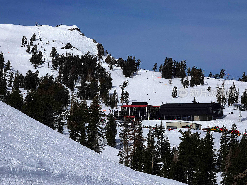 远处的黄金海岸滑雪小屋在缆车的顶部。Palisades Tahoe滑雪胜地，加利福尼亚。